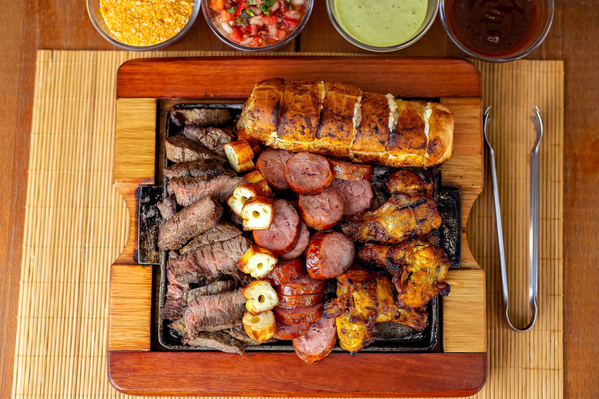Plated steak, pork sausage, and chicken